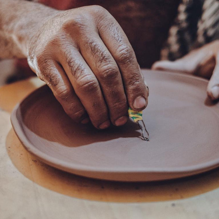 Craftsman Engraving a Ceramic Plate